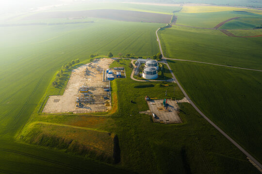 Aerial view of UGS Damborice gas storage facility with industrial tanks and technical structures surrounded by green agricultural fields in Damborice, South Moravian Region, Czechia.