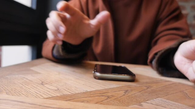 a woman hand pick smart phone from a table o receive the call 