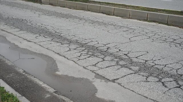 Cracked road surface shows signs of wear and tear