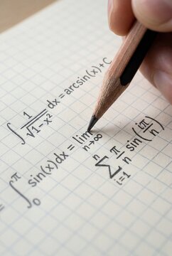 Pencil writing math formulas on grid paper macro education concept