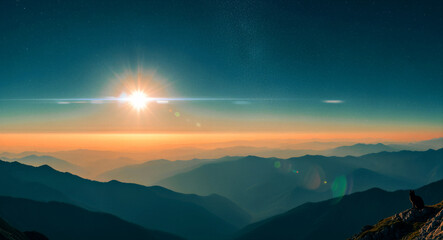 Obraz premium Sunrise over mountain peaks with a starry night sky transition. Silhouette of a cat on a rocky ledge overlooking a misty valley. Nature landscape concept ideal for travel and serenity backgrounds.