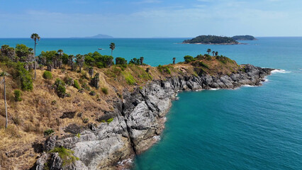 Fototapeta premium Aerial View of Rocky Cliffs and Turquoise Sea at Promthep Cape