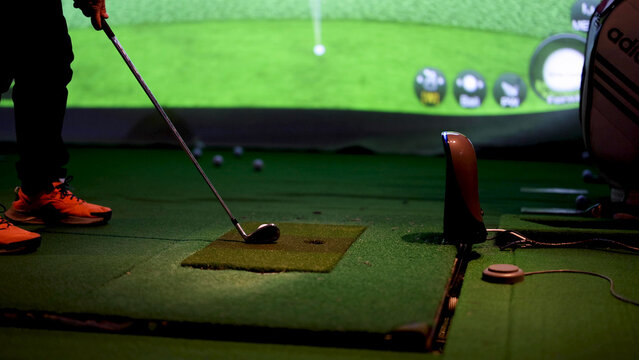 Close Up of Golfer Preparing to Hit Ball in Indoor Simulator