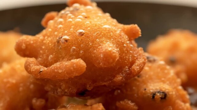 Extreme macro shot of fresh deep-fried fritter covered in sizzling oil bubbles, highlighting crispy golden texture and cooking process.
