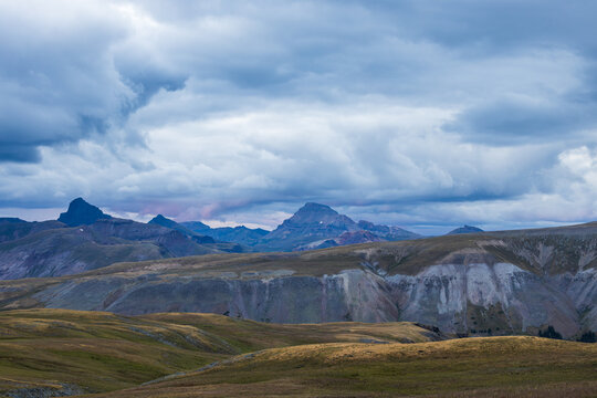mountain peak with tundra meadow and dramatic clouds