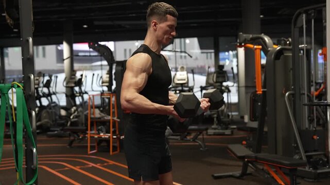 Man exercising with dumbbell. Man athlete lifting dumbbell. Strong man do sport exercise. Gym workout. Sport athlete man with dumbbell, footage. Healthy lifestyle. Biceps muscle. Strong triceps