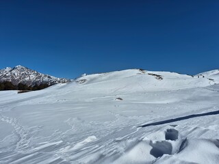 Obraz premium Miniature trekkers walking along a snowy ridge in the Himalayan wilderness of Gorson Bugyal