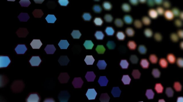 Colorful blurred hexagon symbols loop motion on black background.