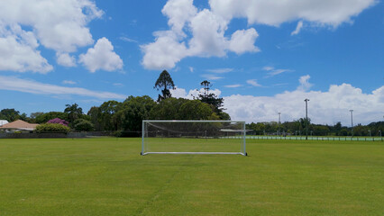 White Soccer Goal on Green Grass Field Under Blue Sky © blueringmedia