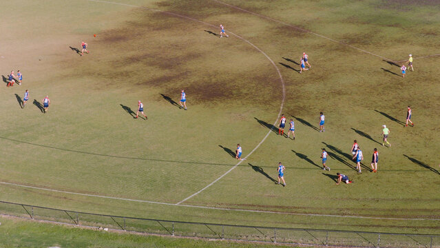 Aerial View of Aussie Rules Football Players on a Sunny Field