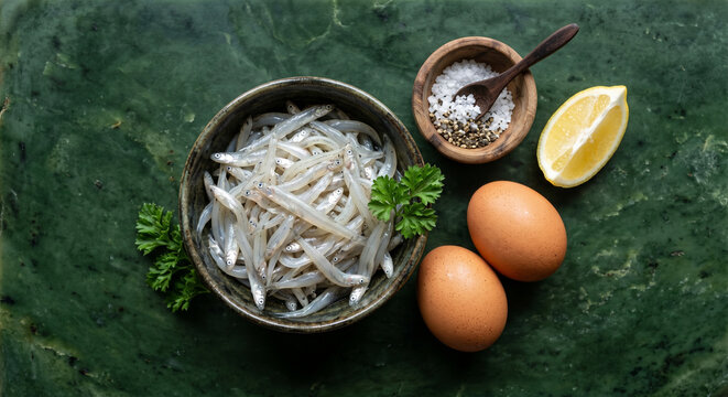 Hyper-realistic top view of Whitebait Fritter ingredients on Pounamu Greenstone