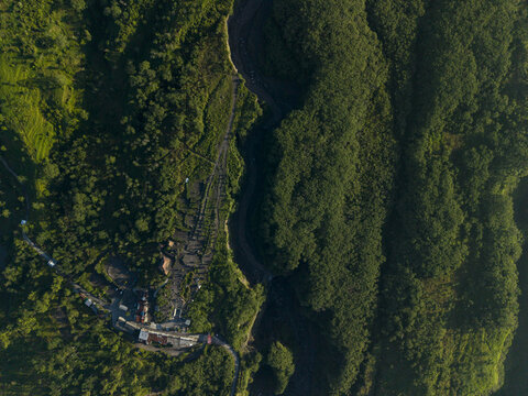 Aerial view of Bunker Kaliadem Merapi surrounded by dense tropical forest and a deep river valley in Kecamatan Pakem, Daerah Istimewa Yogya, Indonesia.