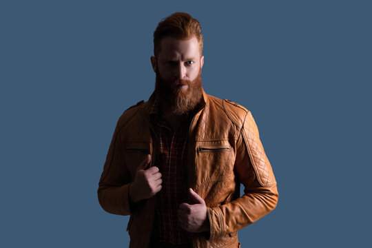 Stylish fashion model. Male casual style. Portrait of guy. Caucasian redhead man in leather jacket. Bearded man isolated on grey. Stylish man with long red beard and moustache. Brutal fashion