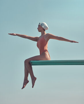 Woman, athlete or swimmer on diving board outdoor with stretching, practice or training for competition. Diver, person and water sports with warm up, fitness or getting ready on platform for contest.