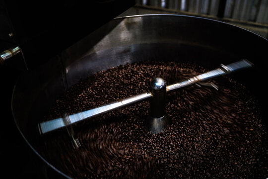 Industrial Coffee Bean Agitator Mixing Dark Roasted Beans In A Metal Cooling Tray