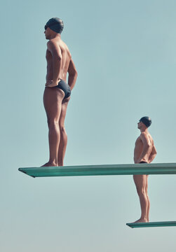 Men, athlete and swimmer on diving board outdoor with sports, practice and training for competition. Low angle, people and diver with swimming exercise, fitness and ready on platform for contest.