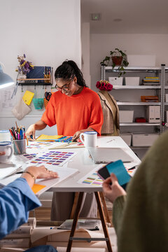 Multiethnic women planning sewing project in atelier studio