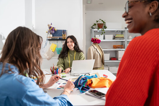 Multiethnic women collaborate in sewing atelier studio