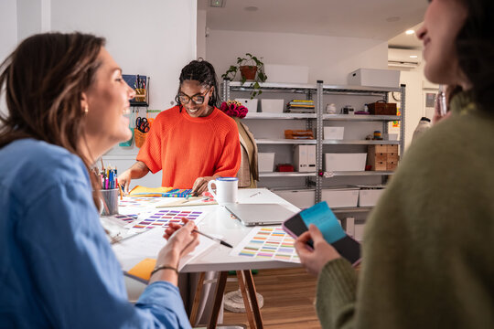 Multiethnic women planning sewing project in atelier studio
