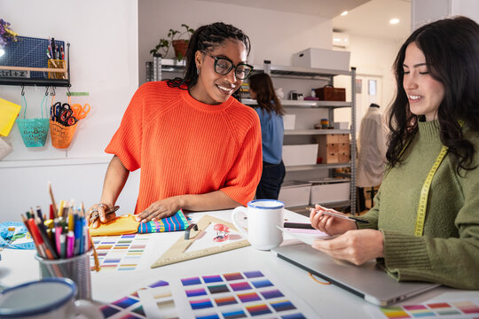 Multiethnic women planning sewing project in atelier studio