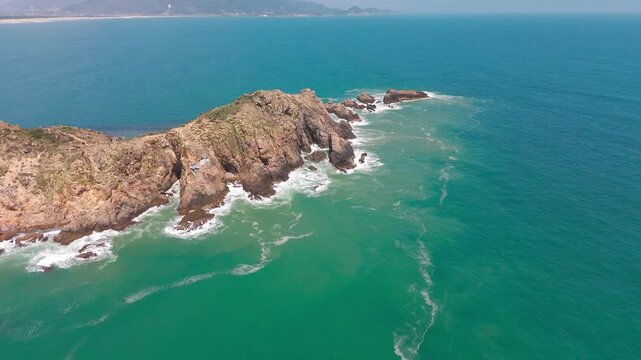 Cinematic aerial drone footage capturing the full dramatic scale of Eo Gio &mdash; Wind Gate &mdash; one of the most striking natural landmarks on the central Vietnamese coastline in Binh Dinh province Quy Nhon