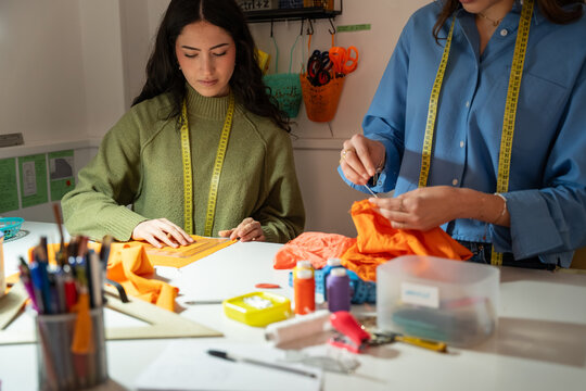 Women tailor working on garment in fashion atelier