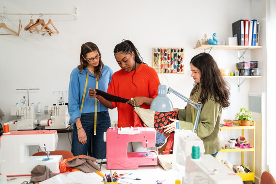 Multiethnic women sewing and designing in a bright atelier