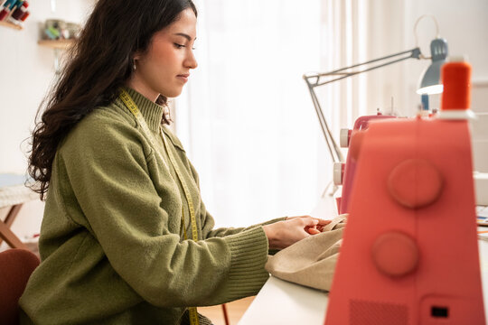 Woman sewing garment in fashion atelier studio workspace