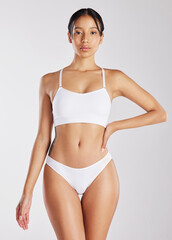 Fototapeta premium Serious, portrait and woman with healthy body in studio, beauty and skincare with natural cosmetics. White background, confident and person in underwear, lose weight and wellness goals in Brazil