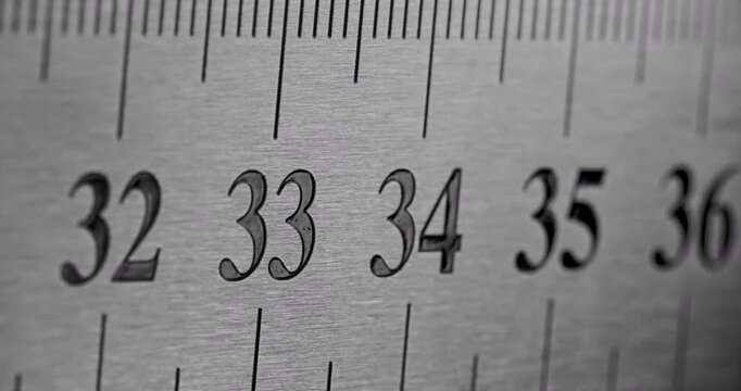 Slow Pan Over Metal Ruler. Smooth slow movement across extreme close-up of metallic ruler with black numbers and brushed surface.