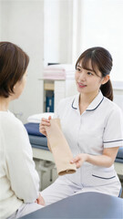 Fototapeta premium 診察室で患者にサポーターを見せながら説明する女性看護師