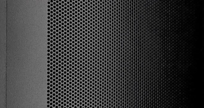 Perforated Metal Surface. A black perforated surface with a repeating pattern of holes creates a textured, industrial look.