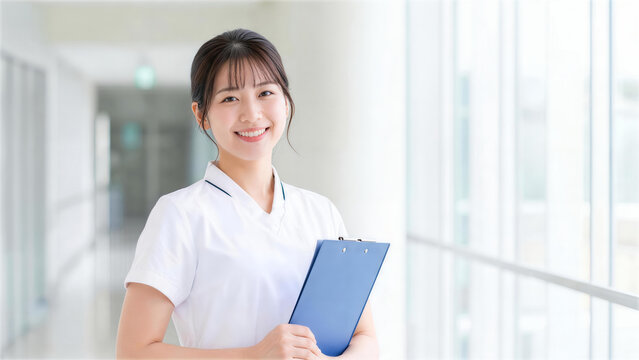 病院の明るい廊下でバインダーを持ち笑顔で立つ女性看護師