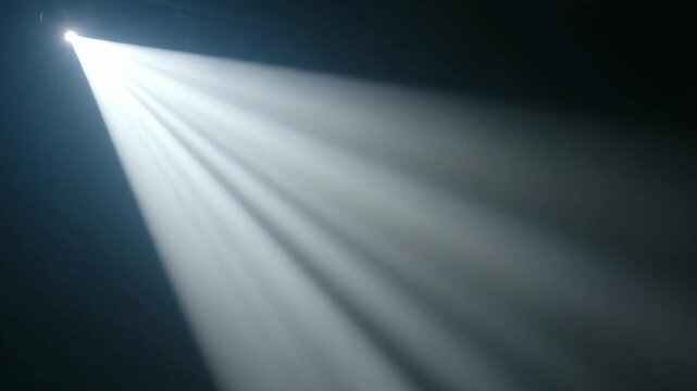 Bright white spotlight shining through smoke in a dark room. Volumetric light beams illuminating a hazy stage. Dramatic theatrical lighting effect