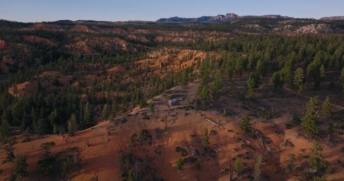 Expansive pine forest and sandstone hills stretch across Dixie National Forest Utah plateau terrain, drone approach