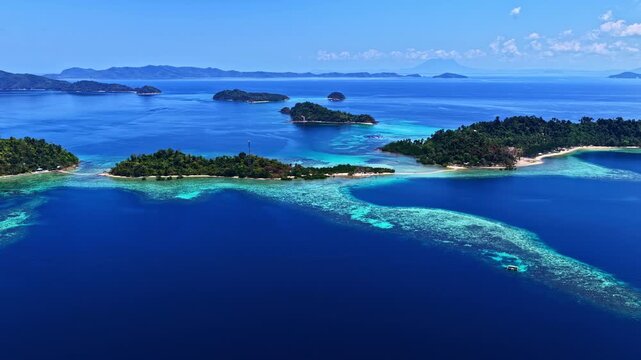 Aerial view of turquoise waters and small islands near Port Barton Beach in the Philippines under a clear blue sky.