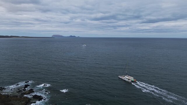 Catamaran ferry crossing sea from &Oacute;rzola, Lanzarote, towards La Graciosa island on cloudy day. Aerial drone, copy space