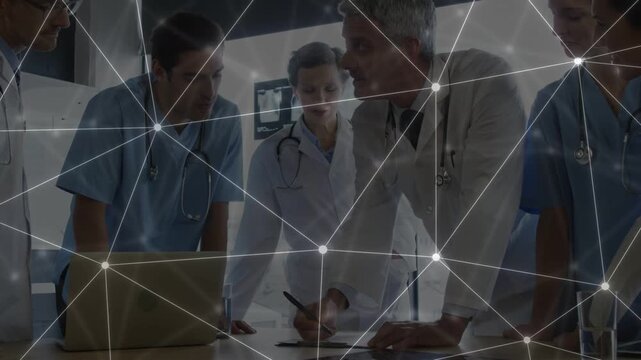 Medical team leaning in senior physician writing by laptop driving case review overlay over group