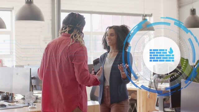 Colleagues conversing in office, man turning tablet while HUD brick icon growing for security