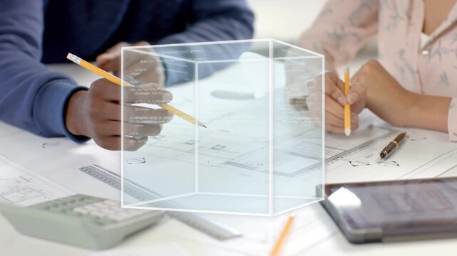 Two designers leaning over plans, pointing, marking, 3D cube appearing rotating above aiding design