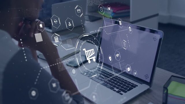 Man sitting at desk gazing at laptop, ecommerce cart interface emerging with hex icons for shopping