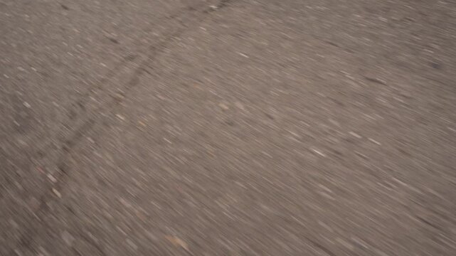 A broken line of white road markings. Close-up in motion.