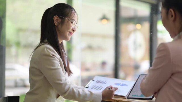 Businesswomen discussing financial charts and data