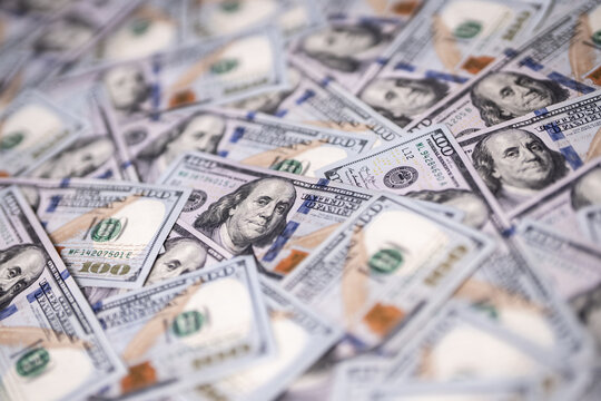 Money background with 100-dollar bills. Texture of US currency. 100 USD banknotes in focus. American hundred-dollar notes spread on a table. Pattern of US dollars for finance concept.