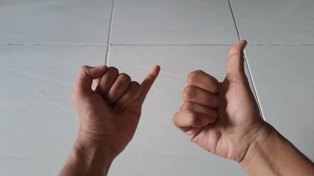 Close-up of an Asian man practicing finger coordination exercises for focus and brain stimulation. The footage shows a thumb and pinky finger switching drill to improve concentration and motor skills.