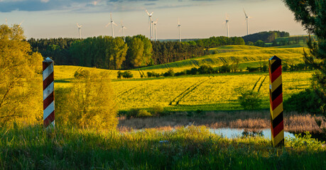 Obraz premium Border posts along the Polish-German border, which runs through ecologically significant green fields