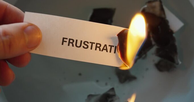 Close-up of paper labeled &ldquo;frustration&rdquo; burning, symbolizing emotional release, stress relief, and letting go of negative feelings.