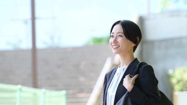 ビル背景で笑顔で歩むビジネス営業女性の横顔、転職や採用などの明るいミドル層の前向きと成長イメージの動画　　