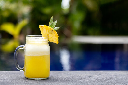Refreshing pineapple juice cocktail by swimming pool