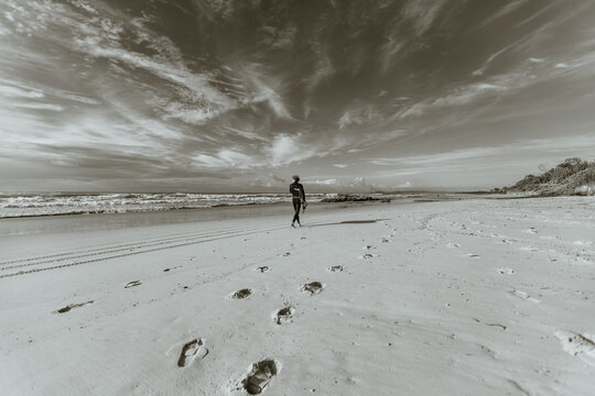 Person walking on a beach leaving footprints
